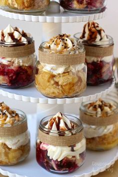 there are many desserts in glass jars on the cake platter and it is ready to be eaten