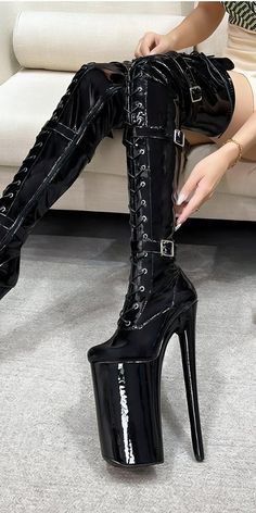 Elevate your style with these bold black platform boots, featuring striking lacing and ultra-high heels for a look that's both daring and sophisticated. Ideal for those who love statement footwear, these thigh-high boots combine avant-garde style with a modern edge, making them a standout addition to any fashion-forward wardrobe. Perfect for adding a touch of drama to your special events or nights out. High Cut Heeled Boots For Fall Party, Winter Party High-cut Platform Boots, Winter Party High Cut Platform Boots, Trendy High Cut Fitted Boots, Trendy Fitted High-cut Boots, Trendy Fitted High Cut Boots, High-top Platform Boots For Night Out, High-top Buckle Platform Boots For Party, High-top Platform Boots With Buckle For Parties