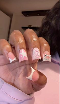 a woman with pink and white nail polish holding up her hand in front of the camera