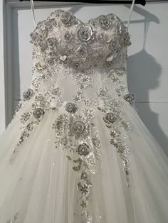 a wedding dress hanging on a hanger