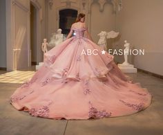 a woman in a pink ball gown is looking down at the floor