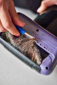 someone is using a brush to remove the hair from their cell phone's screen