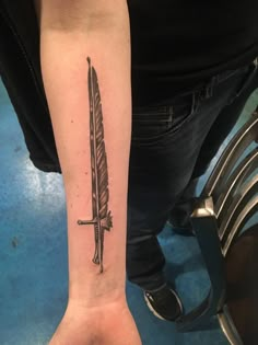 a person with a tattoo on their arm holding a knife