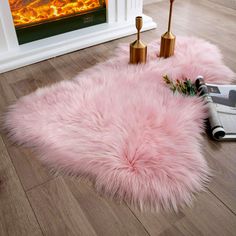 a pink rug on the floor in front of a fireplace