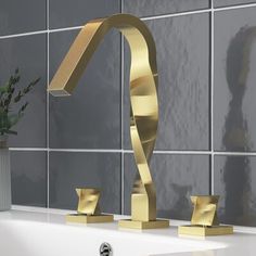 a gold faucet in the shape of a spiral on a white bathtub