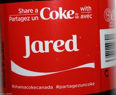 a close up of a bottle of coke with the word jared written on it