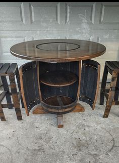 a table and stools made out of wine barrels are sitting in front of a garage door