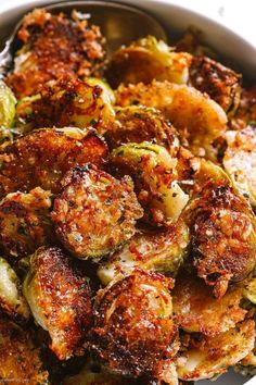 a white bowl filled with cooked brussel sprouts and other food items