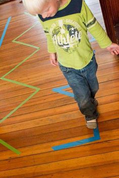 a young boy standing on top of a wooden floor