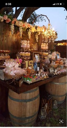 an outdoor dessert table with wine barrels