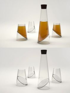 there are four different glass vases and one is filled with orange liquid in it