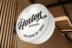 the sign for the kitchen is hanging on the wall in front of the restaurant's entrance