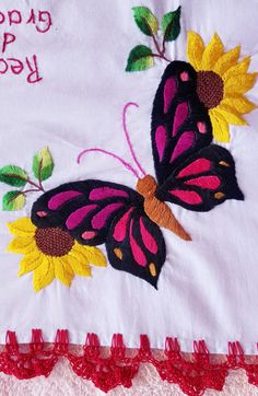 the embroidered butterfly is on top of the white blanket