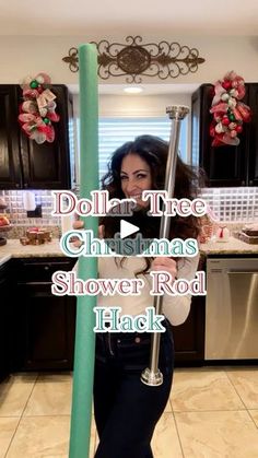 a woman is holding a pole in the middle of a kitchen with christmas decorations on it