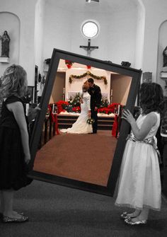 a bride and groom standing in front of the alter at a church with their children