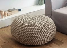 a large round knitted poufce sits on the floor