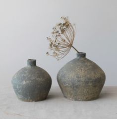 two gray vases sitting next to each other on a table