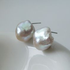 Mini White Baroque Pearl Stud Earrings A pair of stunning natural freshwater baroque pearls like sea shell form, with blue pink lustre, paired with silver ear pins.  The unique organic shapes of the baroque pearls ensure that no two earrings are identical, offering you a truly one-of-a-kind piece of jewelry. Measuring at a versatile size, these stud earrings are ideal for both day-to-day wear and special occasions.  MATERIAL: Sterling Silver, Natural Baroque Pearl PEARL SIZE: Approx. 14*15mm  *Due to hygiene-related reasons, this piece may not be returned.* *Natural materials like pearls have natural growth marks and imperfections, which are their individual beauty and character, ensuring that no two pieces are alike and not considered as quality issues.* ---------- 🚚 ALL ABOUT SHIPPING ✈ White Baroque Pearl Earrings, Round Shape, Silver Baroque Pearl Earrings For Wedding, Pearl White Baroque Pearl Bridal Earrings, Wedding Baroque Pearl Earrings In Pearl White, White Baroque Pearl Bridal Earrings, Delicate Pear-shaped White Bridal Earrings, Pearl White Baroque Pearl Earrings For Wedding, Baroque Pearl Wedding Earrings In Pearl White, White Baroque Pearl Bridal Earrings For Wedding