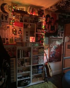 a room filled with lots of musical instruments and pictures on the wall above it is a bookcase full of cds