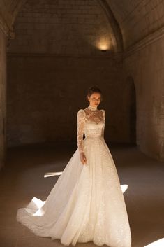 a woman in a wedding dress standing in an archway