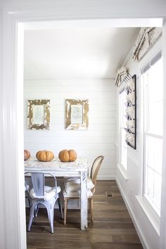 a dining room table with chairs and pumpkins on it