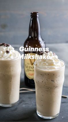 two glasses filled with ice cream next to a bottle of beer on top of a table