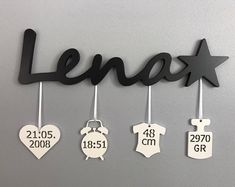 a metal name sign hanging from the side of a wall with baby's names on it