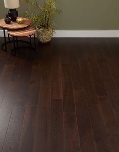 a wooden floor with two tables and a lamp