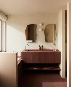 a bathroom with two sinks and mirrors on the wall