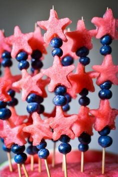 red, white and blue stars are arranged on top of watermelon with berries