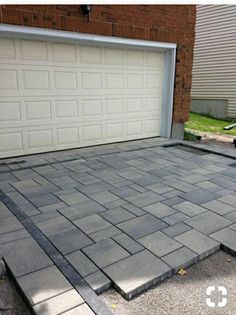 a driveway made out of concrete with a garage door in the background