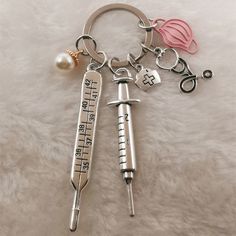 two medical instruments key chains on a white furnishing with a pearl ornament