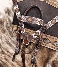 a close up of a horse's bridle on a cowhide background