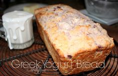 a loaf of bread sitting on top of a cooling rack next to a cup and saucer