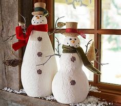 two snowmen standing next to each other in front of a window