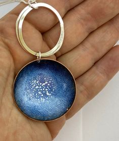 "Contemporary statement jewellery. Large patterned enamel circular disc pendant on a 18\" sterling silver 925 curb chain. The pendant measures approximately 40mm. A copper disc was domed to form a little 'bowl' to form a pendant. Soft White and ultramarine blue enamel was sifted into the \"bowl\" and fired at 90 degrees in the kiln. The pendant was enamelled numerous times to create unique patterns where the enamels have flowed and cooled. The back of the pendant has been enamelled in black for Blue Enamel Round Pendant Necklace, Blue Round Pendant Metal Necklace, Blue Metal Jewelry, Nickel-free Blue Circular Jewelry, Blue Metal Round Pendant Necklace, Blue Metal Necklace With Round Pendant, Blue Hand Painted Round Pendant Necklace, Hand Painted Blue Round Pendant Necklace, Unique Blue Medallion Jewelry