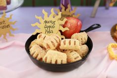 a bowl filled with cookies next to an apple and other decorations on top of a table