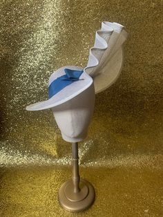 "This stunning 1930's inspired sun hat with has been hand blocked in a lovely ivory straw. The fabulous asymmetric brim elegantly elongates at one side and has been gently folded into a beautiful deco fan detail which swoops us up to reveal the side profile of the face, creating an elegant and feminine silhouette.  Trimmed with a bold blue vintage gros grain hat band and tailored bow.... Perfect for any summer party!  Fixed with elastic for extra security and sent with a lovely vintage hat pin. this hat has been made to fit a 22 -22.5\" head so please be sure to measure your head to make sure it will fit before making your purchase" White Fitted Fedora Straw Hat, Fitted Brimmed Cream Hat, Fitted Cream Brimmed Hat, Elegant White Adjustable Panama Hat, White Elegant Panama Hat, Fitted White Toquilla Straw Sun Hat, White Fitted Toquilla Straw Sun Hat, Elegant White Panama Hat In Toquilla Straw, Fitted Cream Hat With Curved Brim