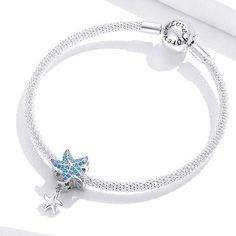 This is charm only, bracelet is sold separately.Experience the beauty of the ocean with our mesmerizing Blue Starfish dangle bead charm for a bracelet. This enchanting charm, crafted from solid 925 sterling silver and featuring a platinum platting and oxidation process, showcases a delicate starfish design with sparkling cubic zirconia and a charming little dangle. As you wear it, let the calming waves and limitless potential of the sea inspire your every step. Add a touch of elegance and marine Sea Inspired, Beaded Dangles, Sterling Silver Charm, Starfish, Silver Charms, Solid 925 Sterling Silver, Bead Charms, Sparkle, 925 Sterling Silver