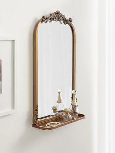 a mirror hanging on the wall above a shelf