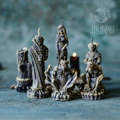 a group of figurines sitting on top of a table next to a candle