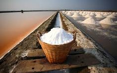 a basket filled with white powder sitting on top of a wooden platform next to a body of water