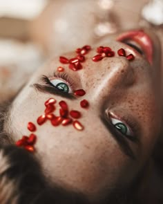 a woman with red glitter on her face and eye make - up looks at the camera