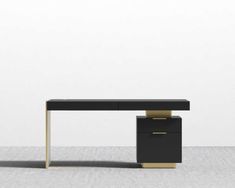 a black desk with gold legs in an empty room