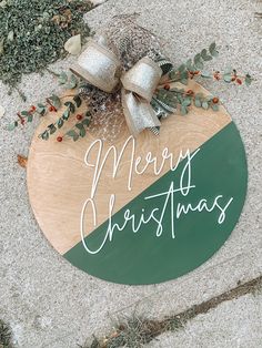 a merry christmas sign with bells and greenery