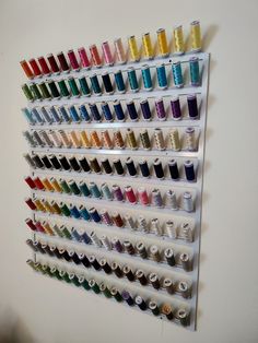 the wall is filled with many different colors of thread