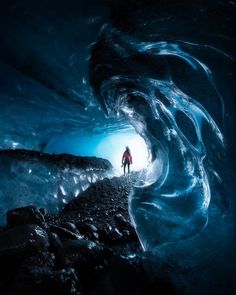 a man standing in an ice cave looking at the light