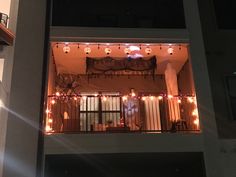 an apartment building with lights on the balconies and balcony railings at night