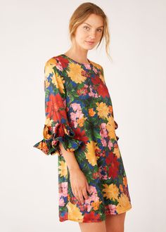 Our bold, beautiful Bronwyn mini dress is designed for easy elegance with a floral flair! Featuring a trapeze silhouette and ¾ length sleeves, this satin dress makes a statement with ruffled cuffs. Dress it up with a colorful pump and a sparkling earring to stand out at any event. Crew neckline Ruffle cuff, quarter-length sleeve Shift silhouette Mini length Back zipper Fully lined Fabric: Satin, 100% Polyester Care: Hand wash or dry clean recommended Multicolor Knee-length Puff Sleeve Dress With Floral Print, Bold Print Multicolor V-neck Dress, Vibrant Print A-line Beach Dress, Multicolor Floral Print Puff Sleeve Knee-length Dress, Multicolor Floral Print A-line Mini Dress, Long Shorts, New Arrival Dress, Black Tie, Satin Dresses