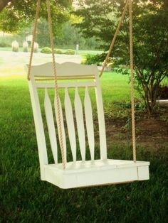 a white wooden swing in the grass